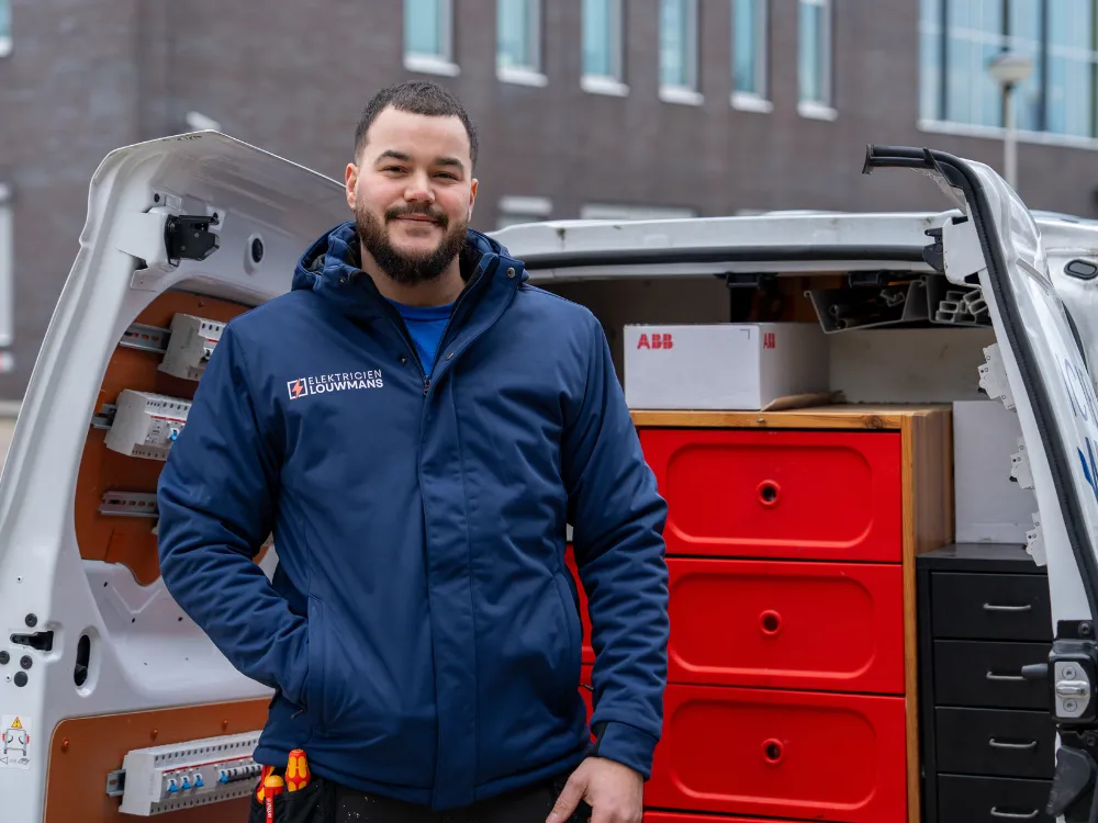 Elektricien staat bij de geopende bedrijfsbus